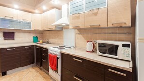 Une cuisine moderne avec des meubles de couleur brun foncé, une cuisinière blanche et un four à micro-ondes.