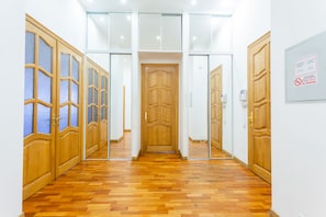 Un pasillo con puertas y piso de madera.