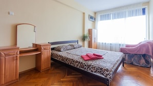Um quarto com cama, escrivaninha e uma cadeira.