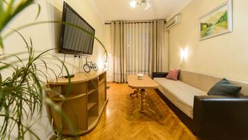 Apartamento básico, 1 quarto | Área de estar | TV de tela plana
