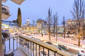 Eine verschneite Straßenszene in der Stadt mit Gebäuden, einem sichtbaren Hotel und einem mit Schnee bedeckten Geländer.