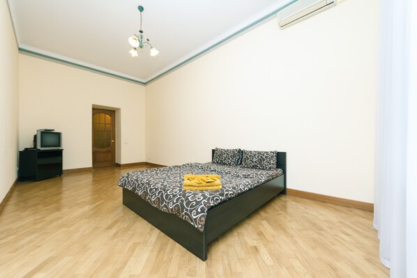 A bedroom with a bed, a television, and a door. - 4 bedroom apartment at the Palace of Sport (Kyiv)