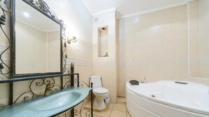 A bathroom with a large mirror, a sink, a toilet, and a bathtub.