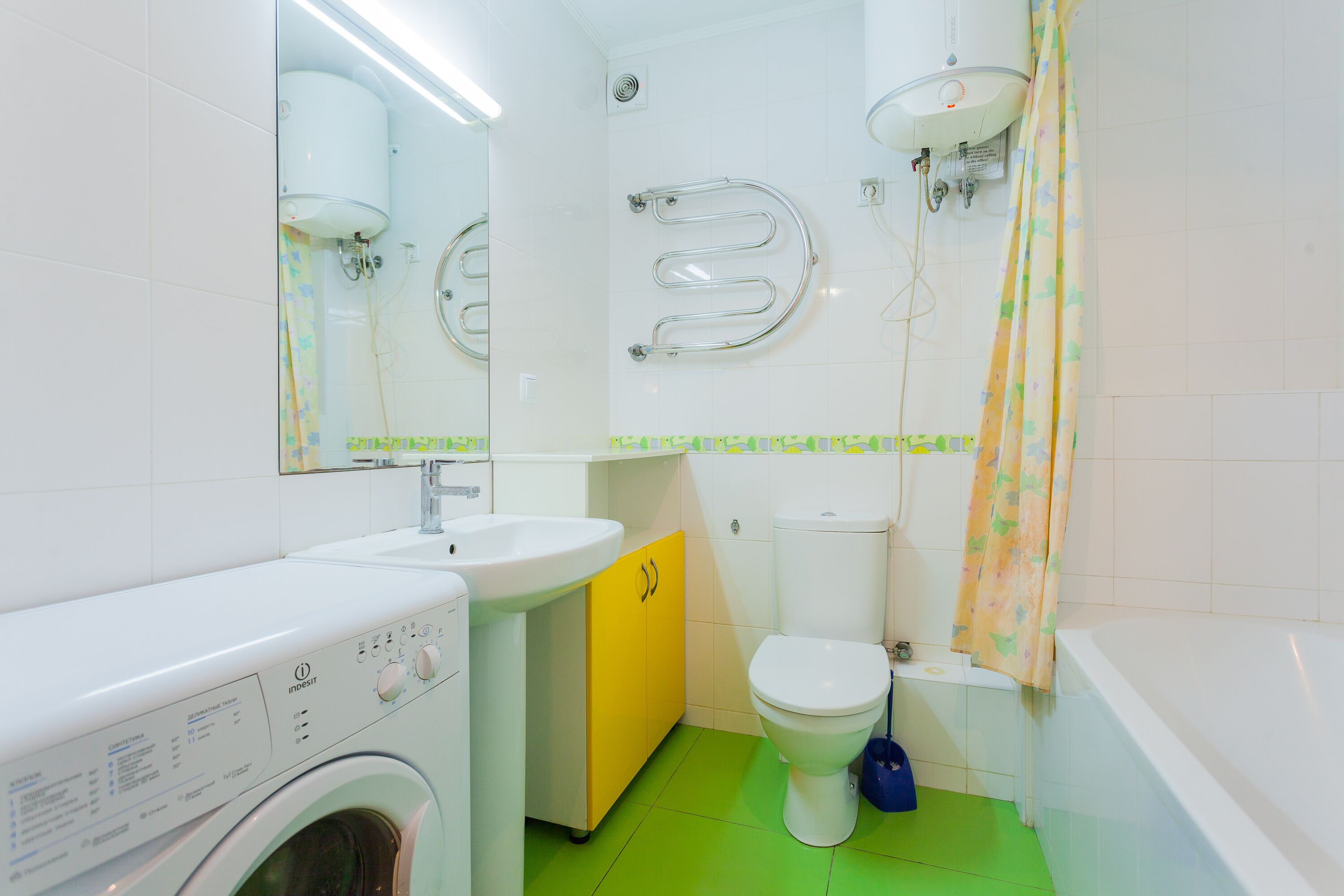 A compact bathroom with a washing machine, a sink, a toilet, and a bathtub.