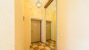 A hallway with a checkered floor, a mirror on the wall, and two doors with a 'No Entry' sign. - Cozy studio apartment near Palace Ukraina (Kyiv)