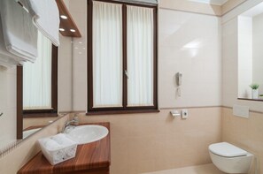 A modern bathroom with a wooden vanity, a white sink, a toilet, and a shower. - Luxury Rooms near Beach 2 (Split)
