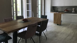 Una cocina moderna con armarios blancos, una mesa de comedor de madera y una pequeña isla.