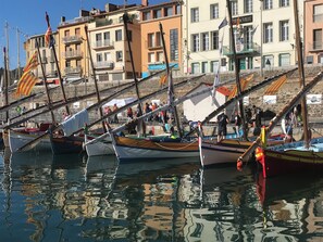 A harbor with several boats docked, surrounded by buildings with balconies and a stone wall. - Renovated flat, air-conditioned, with a view of the harbour (Port vendres)