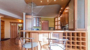 Eine Küche mit Bar, Holzschränken und einem Weinkühlschrank.