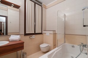 A modern bathroom with a bathtub, toilet, and vanity. - Luxury Rooms near Beach 3 (Split)