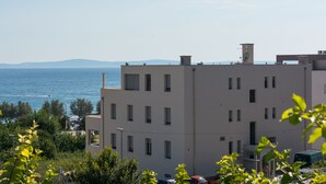 Un edificio de varios pisos con techo plano, varias ventanas y una antena parabólica.