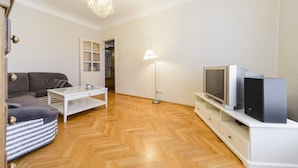 A modern living room with a sofa, TV, and a lamp. - Apartment near Olympic Stadium (Kyiv)