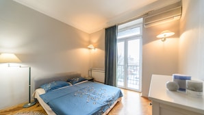 A bedroom with a bed, bedside lamps, a window, and a small table with toiletries. - Apartment near Olympic Stadium (Kyiv)