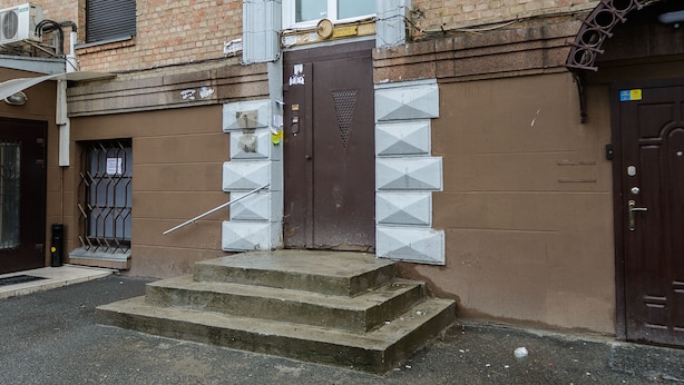 A brick building with a brown door, a small window, and a metal balcony. - Apartment near Olympic Stadium (Kyiv)
