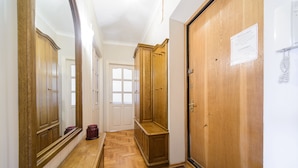 A hallway with wooden doors, a bench, and a rug. - Apartment near Olympic Stadium (Kyiv)