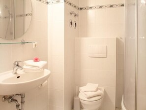 Ein Badezimmer mit Waschbecken, Toilette und Dusche.