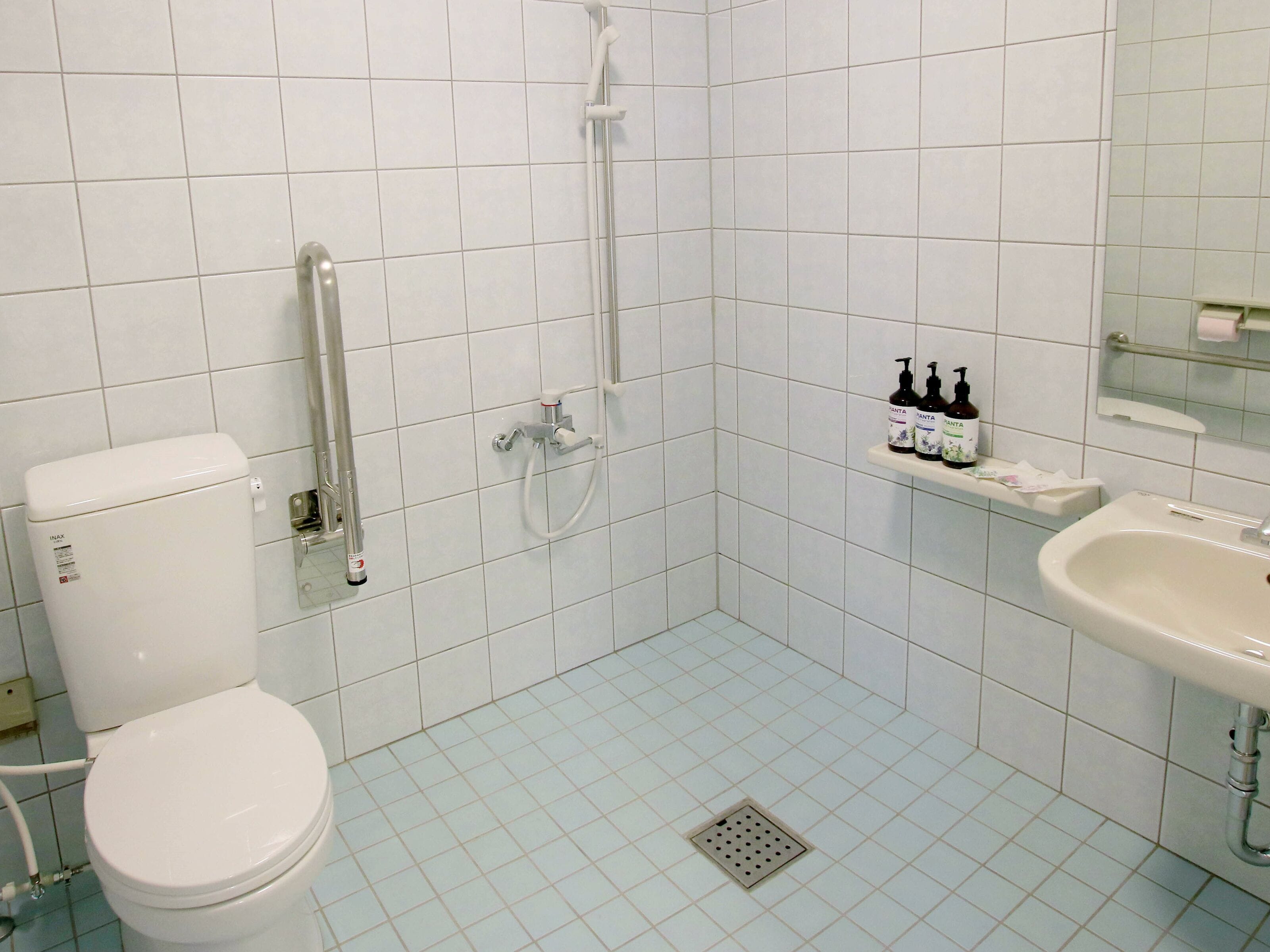 Une salle de bain avec des toilettes, une douche et un lavabo.