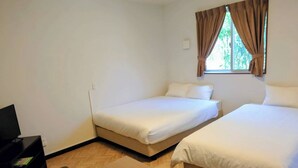A hotel room with two beds, a TV, and a wooden coffee table.