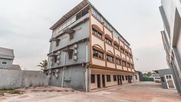 A multi-story building with a flat roof and a balcony on the upper floor.
