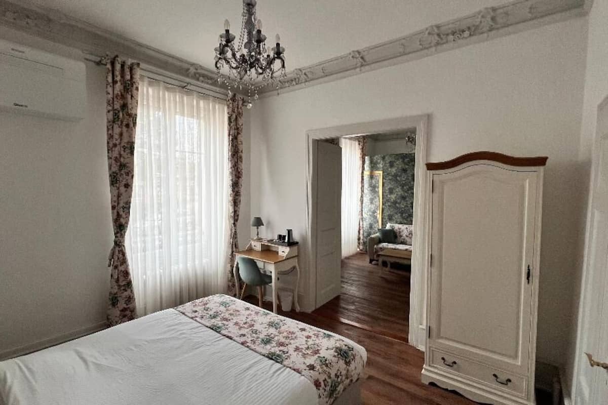 A bedroom with a bed, a desk, a chair, and a wardrobe.