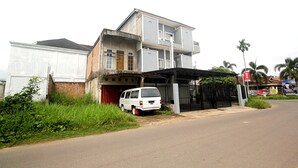 A two-story building with a white van parked in front.