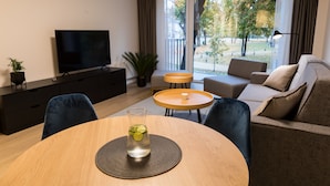 Un salon moderne avec un téléviseur, un canapé et une table basse.