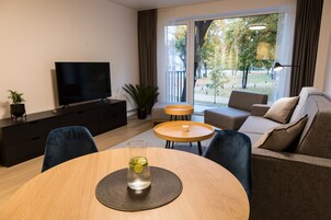 Una sala de estar moderna con televisor, sofá y mesa de centro.