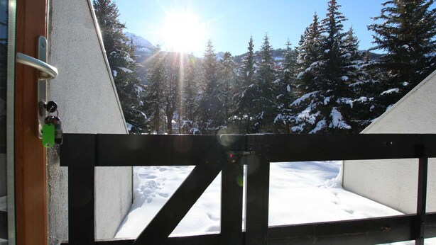 Schneebedeckte Landschaft mit einem Holztor und blauem Himmel.