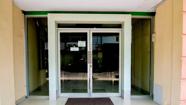 A building entrance with a glass door and a doormat. - Hotel O Grand Azizah (Makassar)