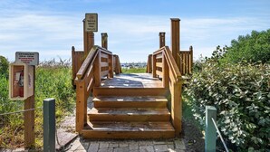 A wooden staircase leading to a smoke-free facility with a sign indicating grill cooking hours. - 7th Floor Windy Hill Condo. Fitness Room, Pools, Wifi | Windy Hill Dunes - 704 (North Myrtle Beach)