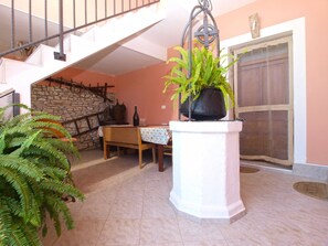 Step into this inviting space, featuring a spacious interior with a high ceiling and a staircase leading to an upper level.