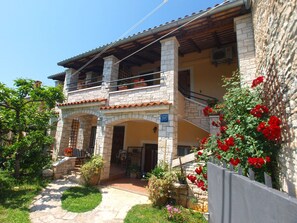 Guesthouse with a balcony and potted plants.