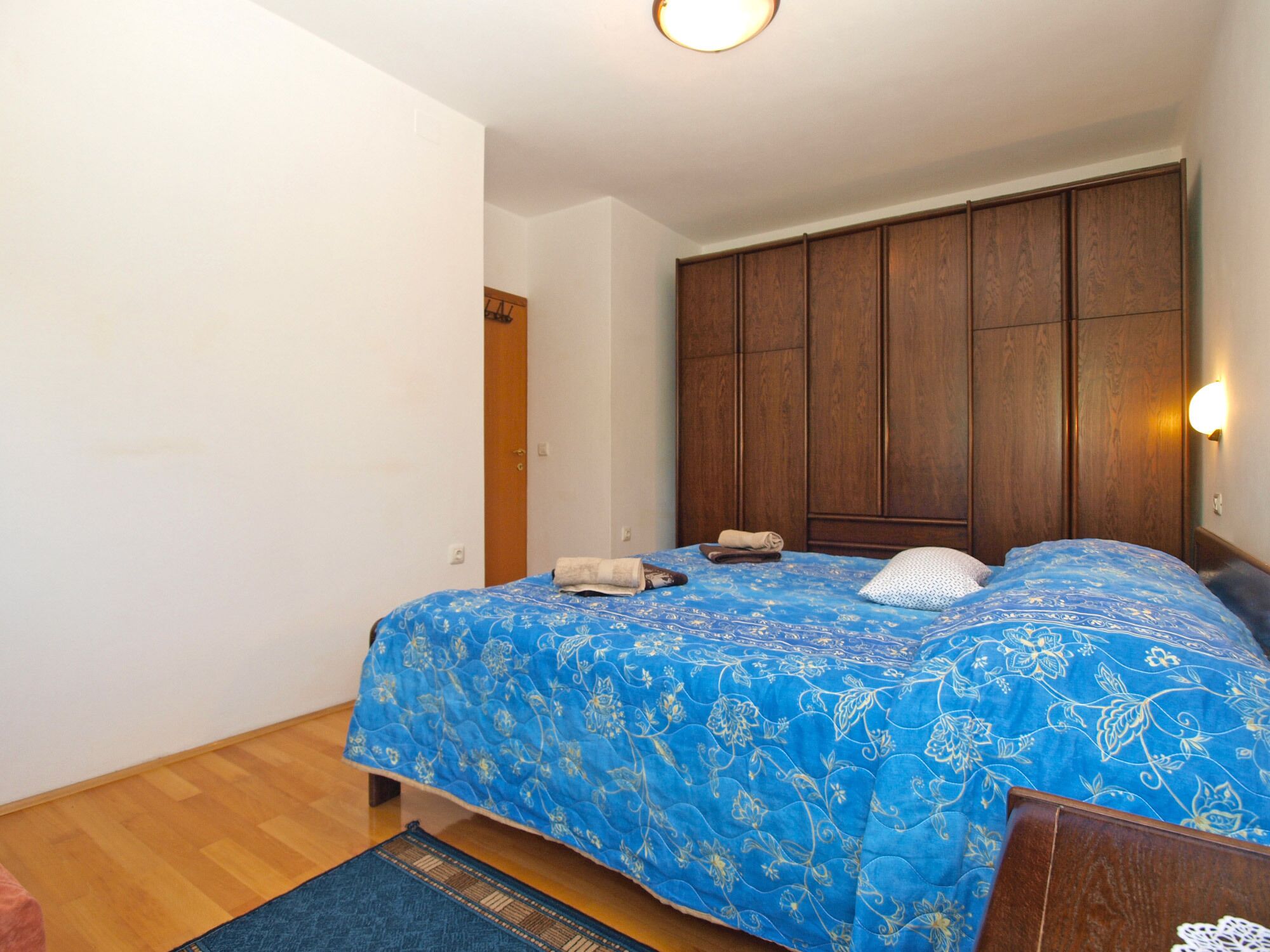 Ein Schlafzimmer mit einem Bett, einem Holzschrank und einem Nachttisch.