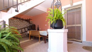 A dining area with a table set for two, a potted plant, and a staircase leading to an upper level.