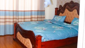 Une chambre à coucher avec un lit en bois, des rideaux à rayures, un baldaquin blanc et un papier peint à motifs.