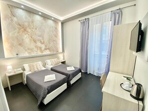 A hotel room with two beds, a desk, a television, and a large marble wall. - Residenza  Giustiniani (Rome)
