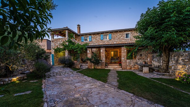 Una casa de piedra con un camino de piedra que lleva a la entrada.