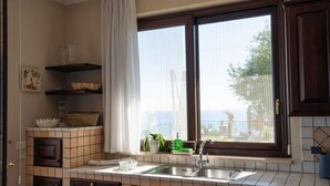 Cucina con finestra, lavello e ripiani con utensili da cucina.