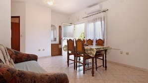 A dining area with a table, chairs, and a sofa. - Apartment 1858/22636 (Istria - Valbandon), 1000m from the beach (Valbandon)