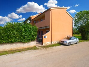 Un edificio de dos plantas con un coche estacionado al frente.