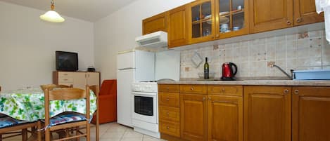 Réfrigérateur, un four, surface de cuisson, vaisselle et ustensiles