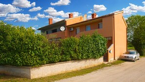 A two-story building with a satellite dish, a car parked in front, and a well-maintained hedge. - Apartment 1858/22637 (Istria - Valbandon), 1000m from the beach (Valbandon)