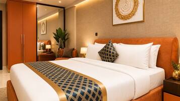 A hotel room with a large bed, a nightstand with a lamp, a potted plant, and a wall-mounted artwork.