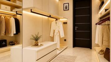 A modern walk-in closet with organized shelves, a bench, and a door.