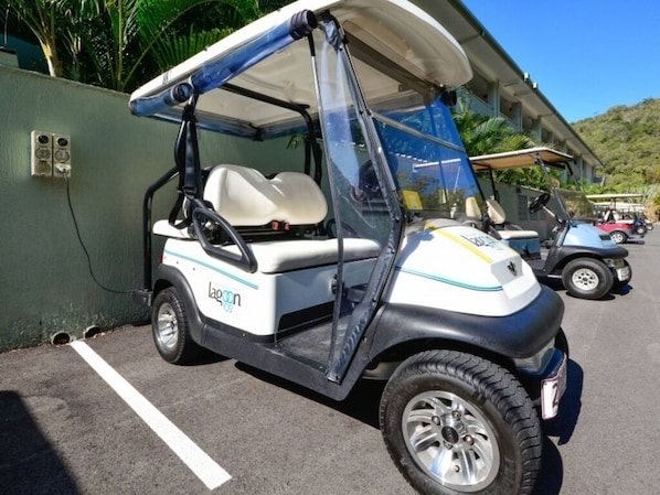 A golf cart parked in a parking lot with a building in the background. - Lagoon 102, The Beach Shack, Hamilton Island (Hamilton Island)