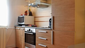 Une cuisine moderne avec des meubles en bois, un four encastré et un four à micro-ondes.