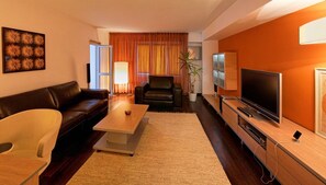 Una sala de estar moderna con un sofá, una mesa de centro, un televisor y una planta.