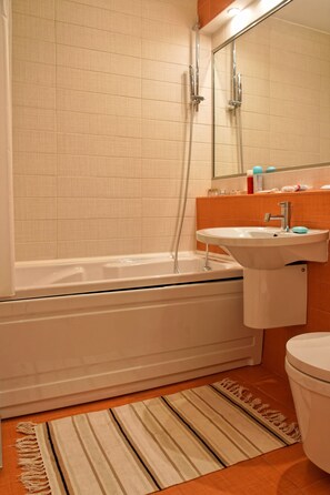 Un baño con bañera, lavabo e inodoro.