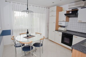 A compact kitchen with white cabinets, a microwave, and a stove.