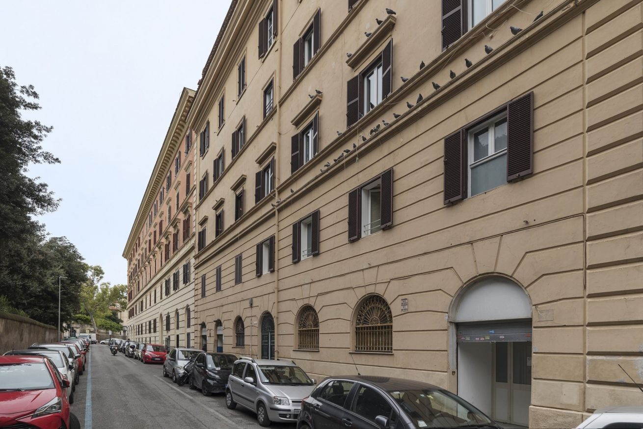 Ein mehrgeschossiges Gebäude mit parkenden Autos entlang der Straße.